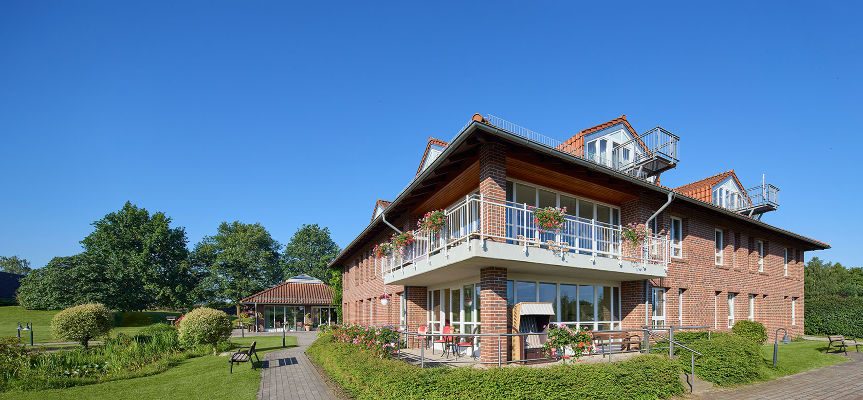 Sommerliche Außenansicht mit Balkonen und Terrasse